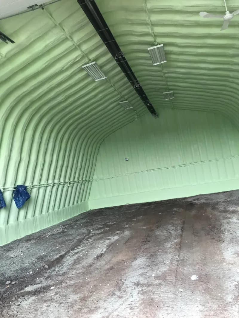 Quonset-style building interior with spray foam Curved metal building interior fully lined with Genyk Boreal Nature Elite 2 lb closed-cell spray foam and a ceiling fan